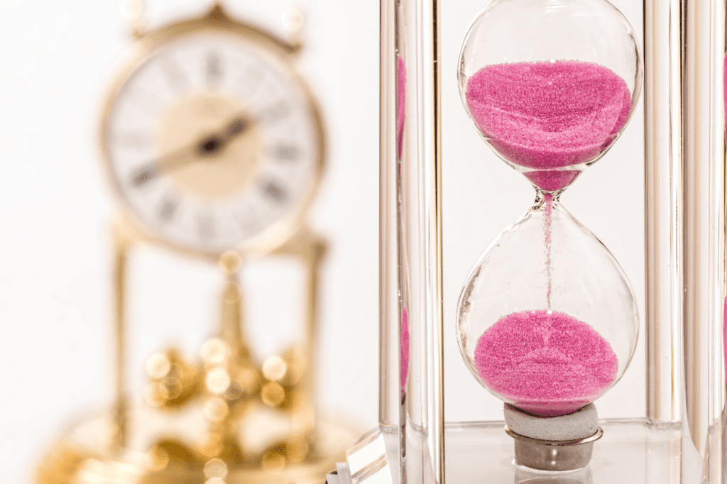 A sand timer and a clock beside it