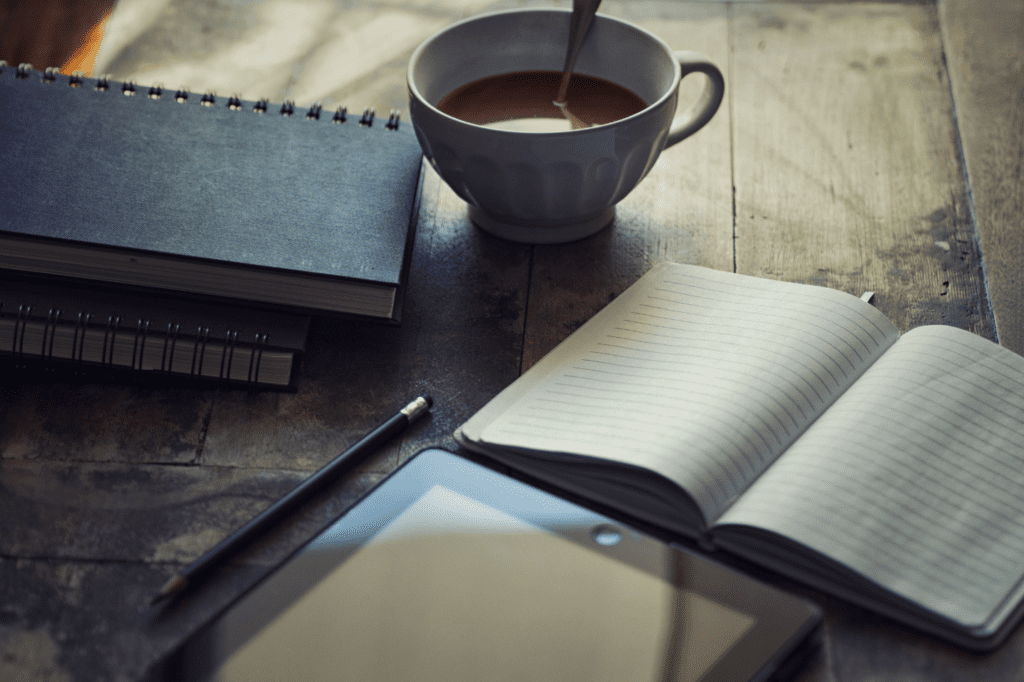 Notebooks and a cup with liquid.